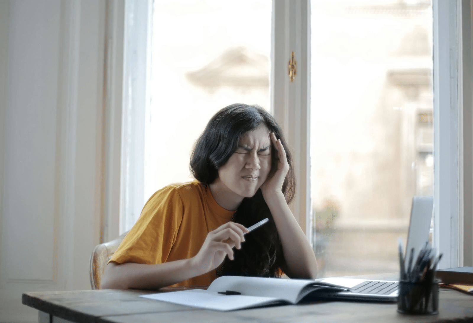 Girl with a migraine headache unable to focus on school work